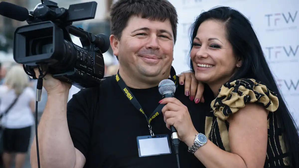 Фотограф в Турине на съёмке: стильная пара и фотограф с камерой в центре города, естественный дневной свет, живые эмоции